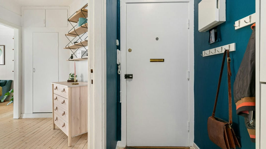 A hallway with blue walls and a white door