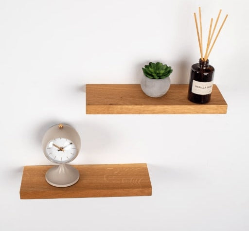 Wooden shelves with a clock and decorative items on a white background