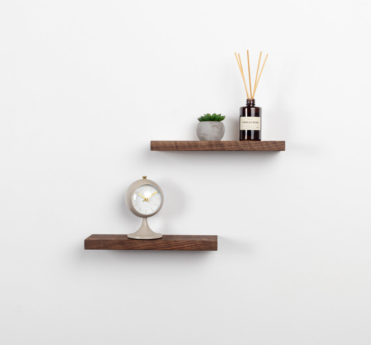 Two wooden shelves with decorative items on a white wall