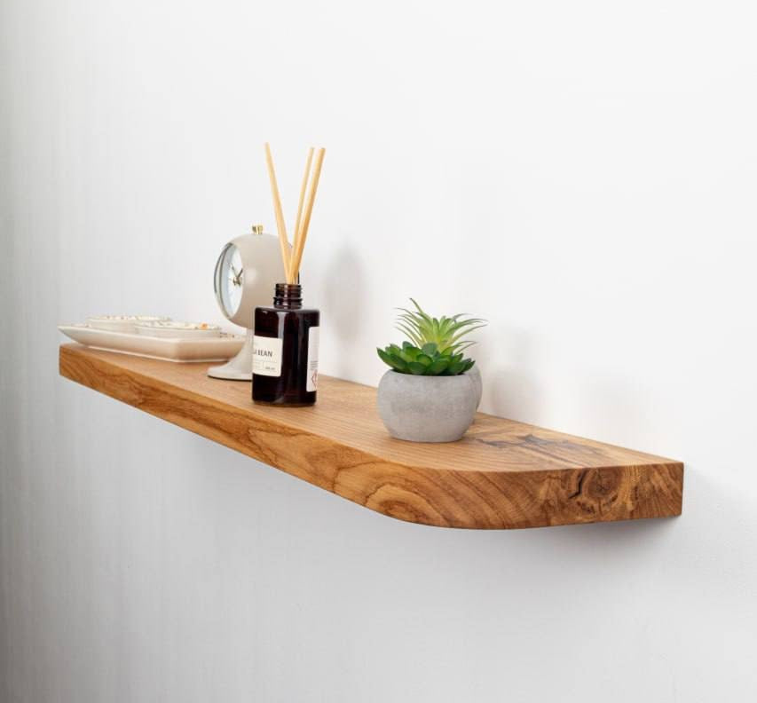 Wooden shelf with decorative items on a white wall