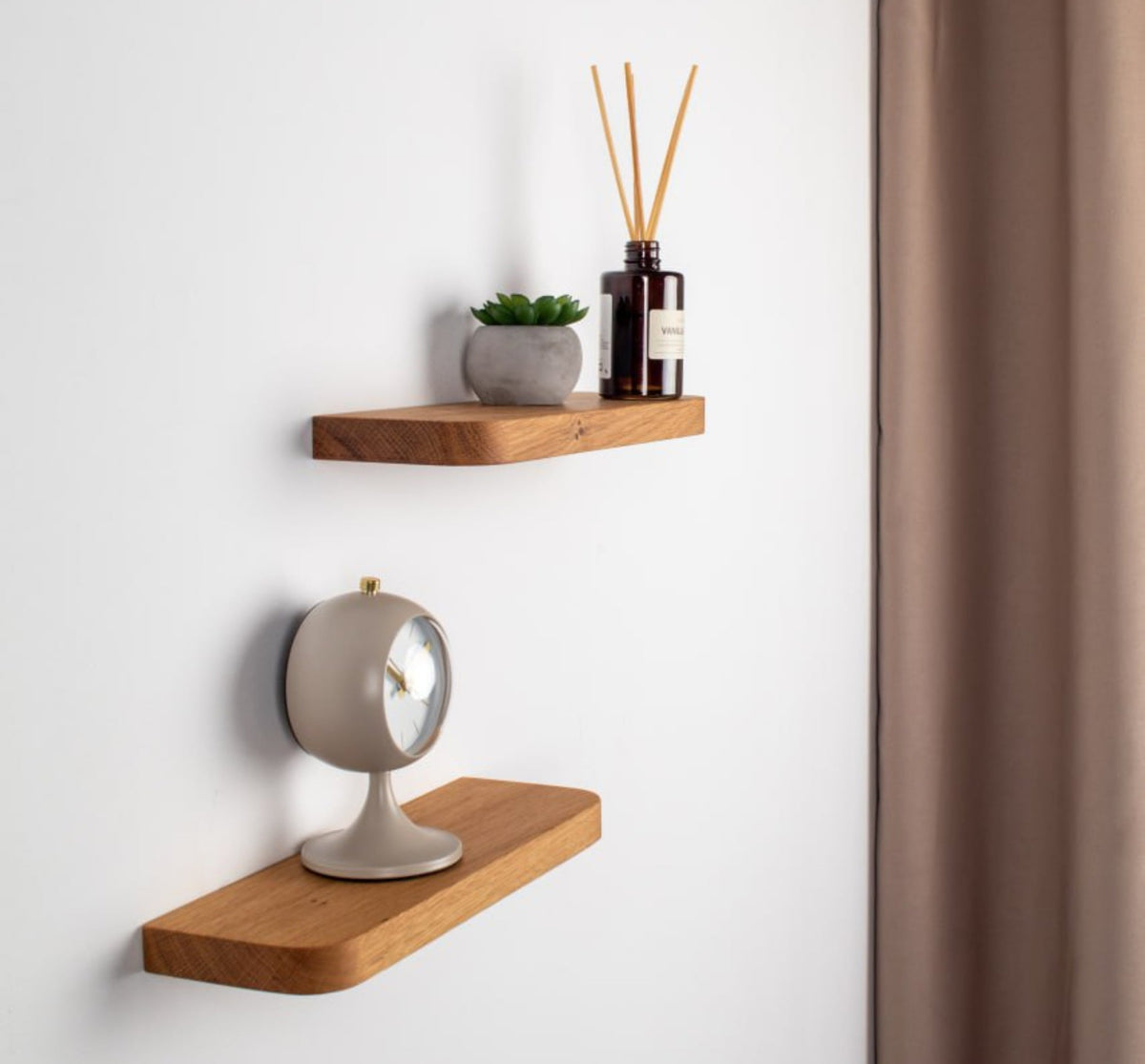 Two wooden shelves with decorative items on a white wall.