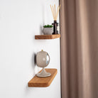 Wooden shelves with decorative items against a white wall.