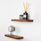 Two wooden shelves with decorative items on a white wall