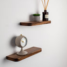 Wooden shelves with a clock and decorative items on a white wall