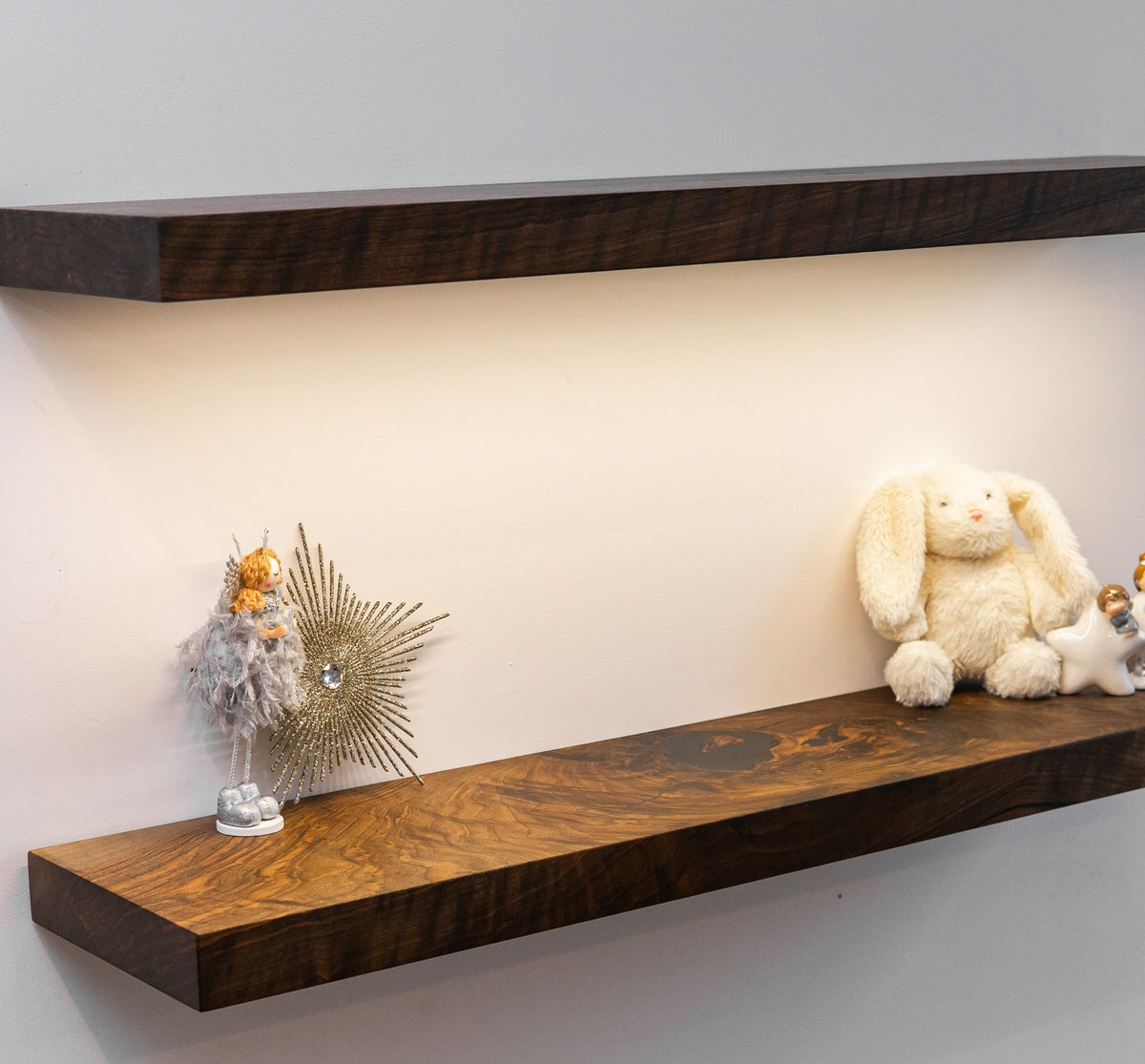 Wooden shelves with decorative items against a plain wall