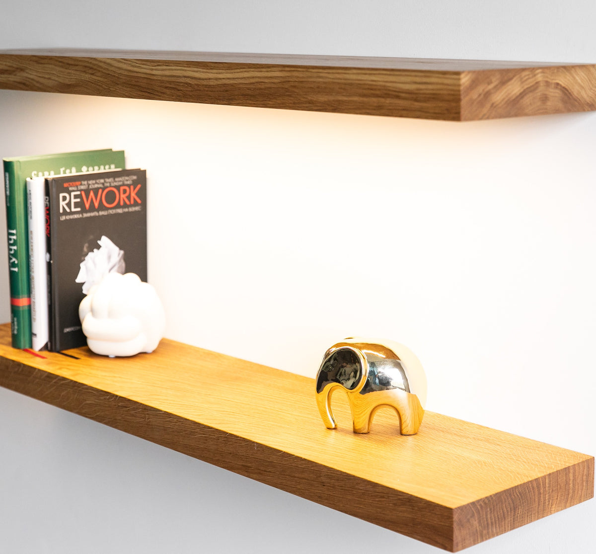 Wooden shelf with books and decorative items on a white background
