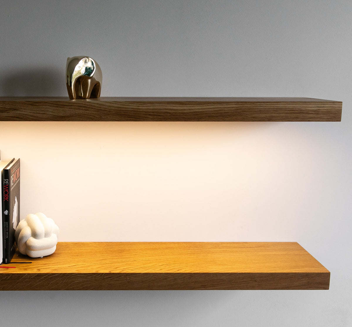 Two wooden shelves with decorative items on a plain background