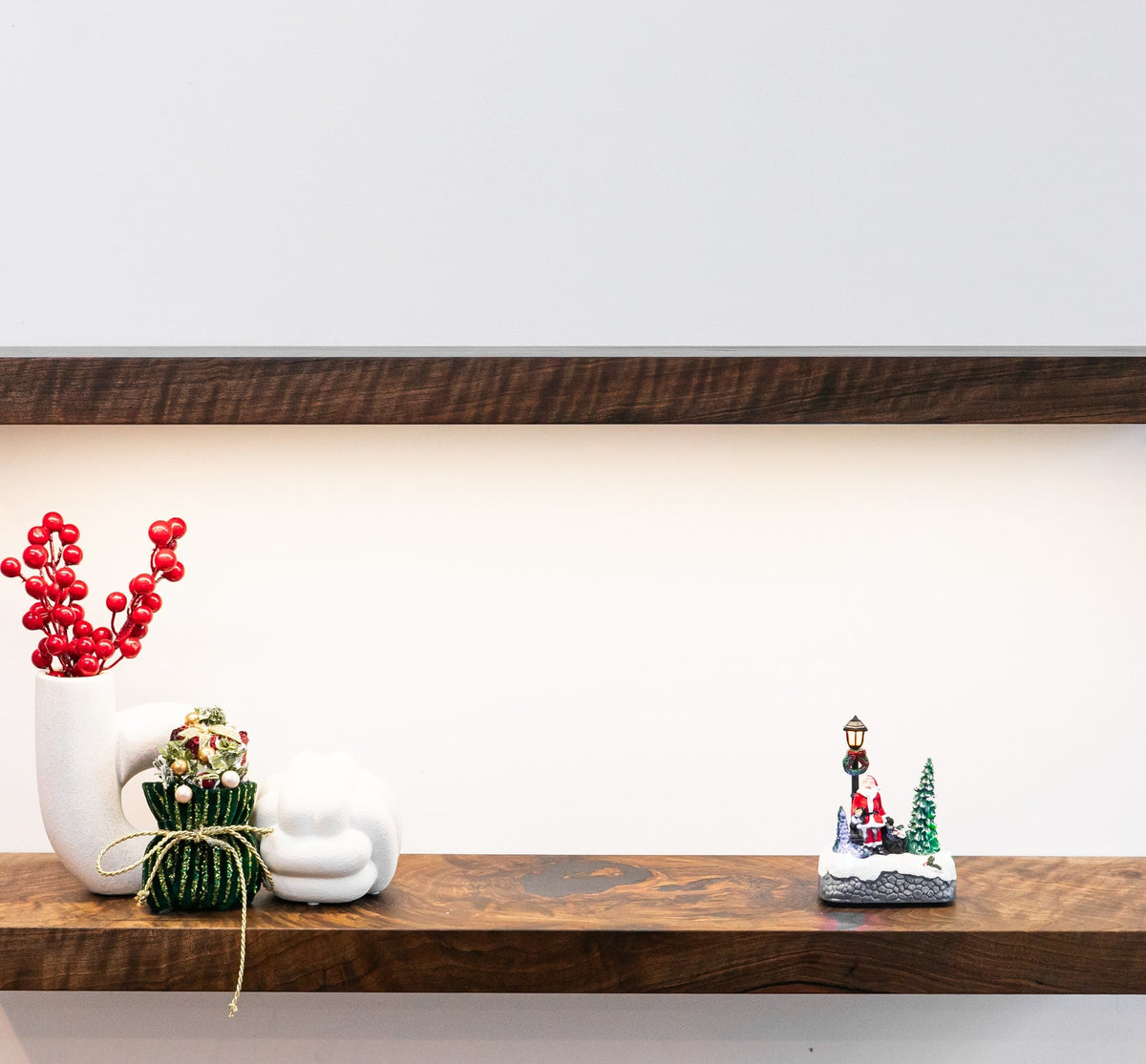 Decorative items on a wooden shelf against a white wall