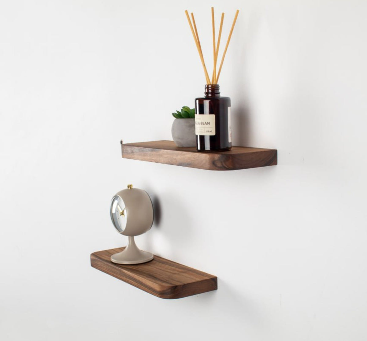 Wooden wall shelves with decorative items on a white wall