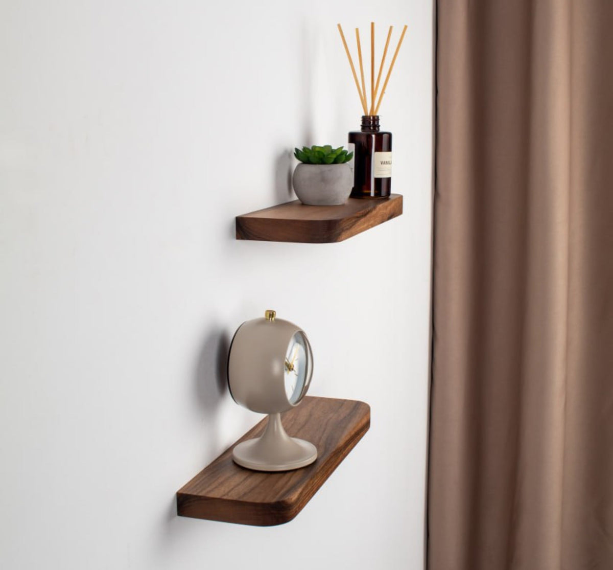 Two wooden wall shelves with decorative items against a white wall.