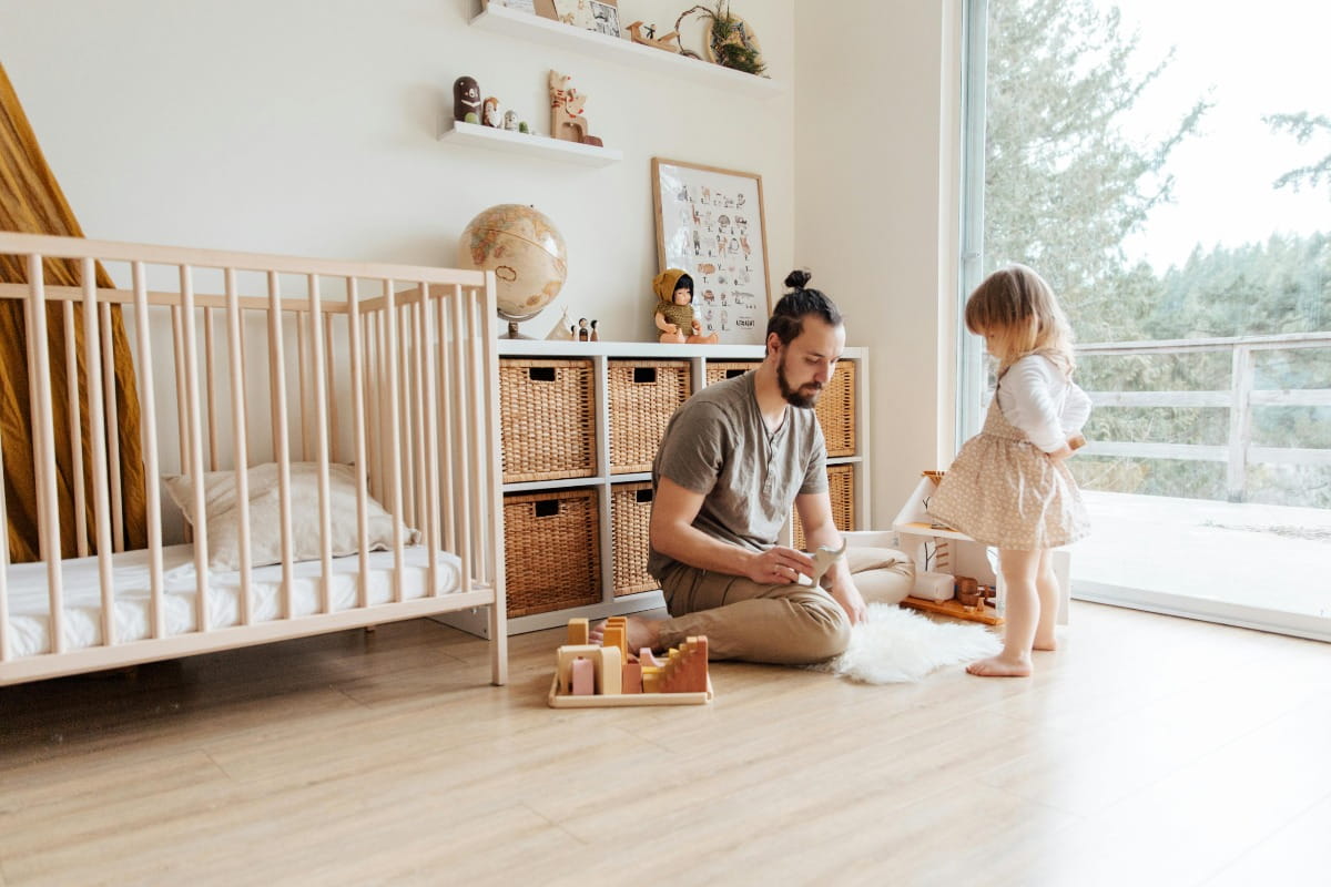 A man playing with a child in  a nursery