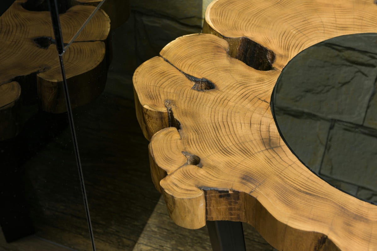Close-up of a natural wood slab table with visible tree rings and knots