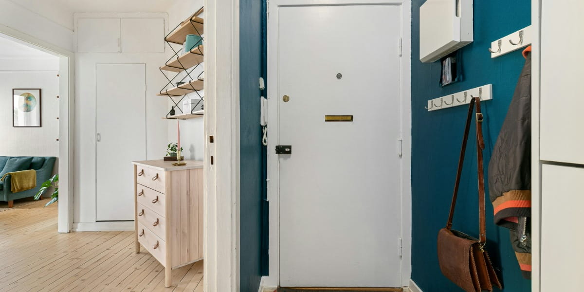 A hallway with blue walls and a white door 