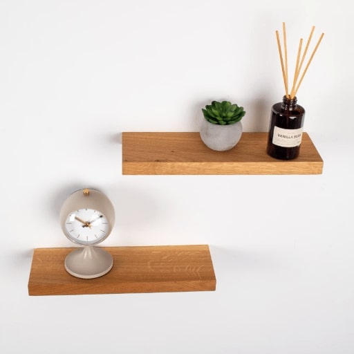 Wooden shelves with a clock and decorative items on a white background
