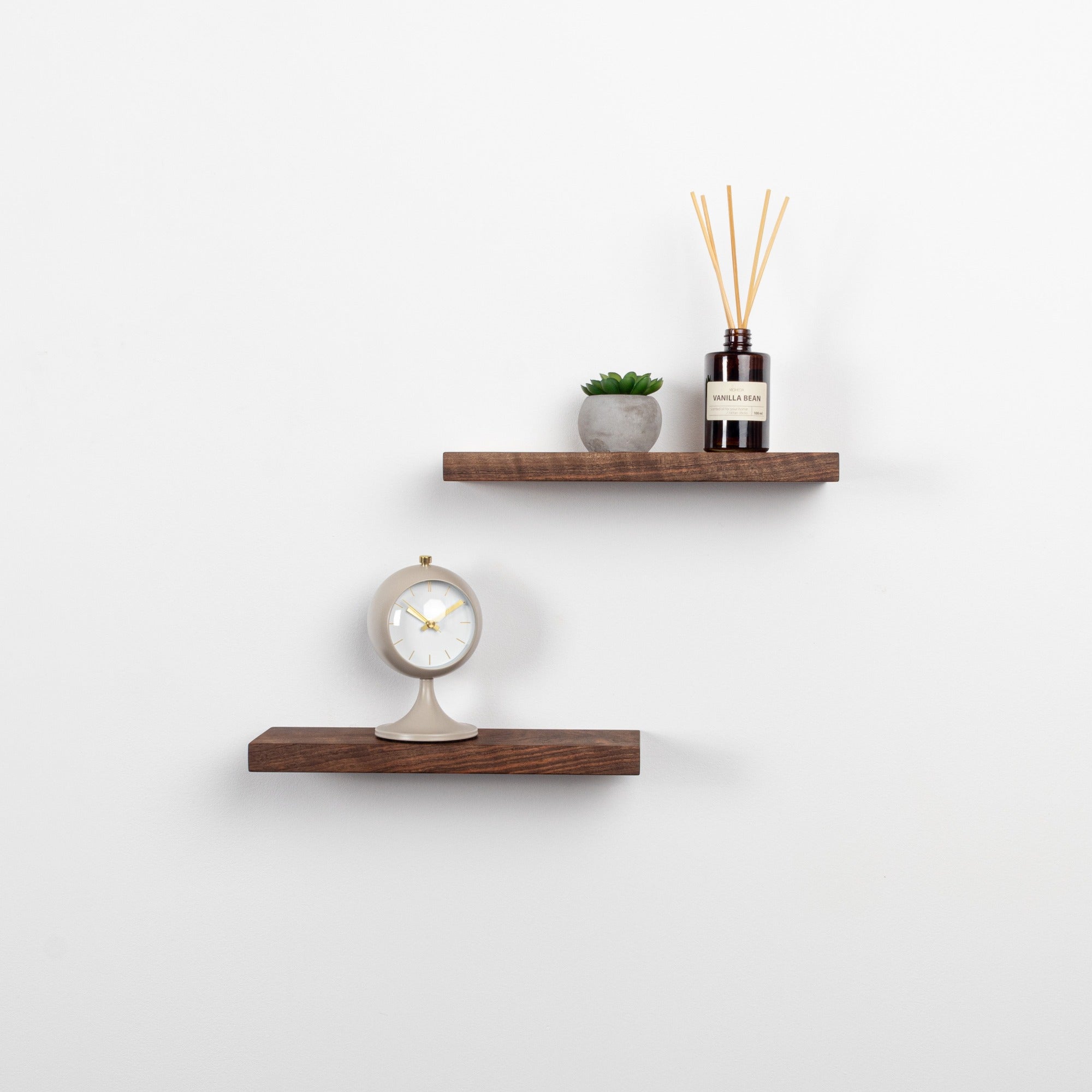 Two wooden shelves with decorative items on a white wall