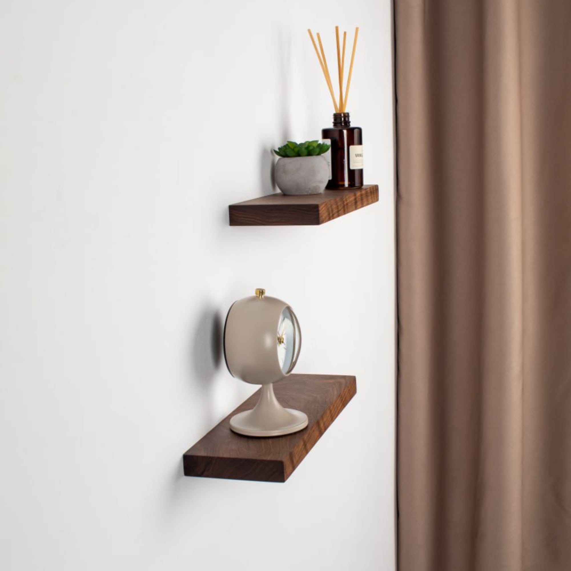 Two wooden shelves with decorative items against a white wall.