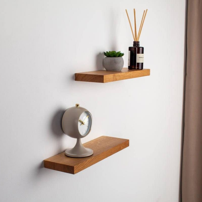 Two wooden shelves with decorative items on a light gray wall.