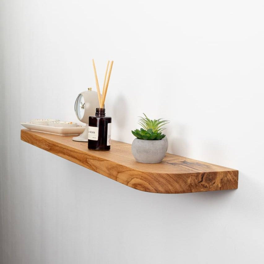 Wooden shelf with decorative items on a white wall