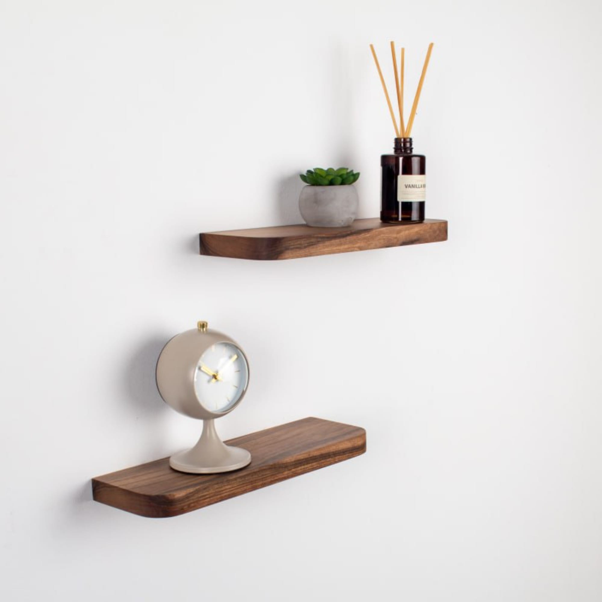 Two wooden shelves with decorative items on a white wall.