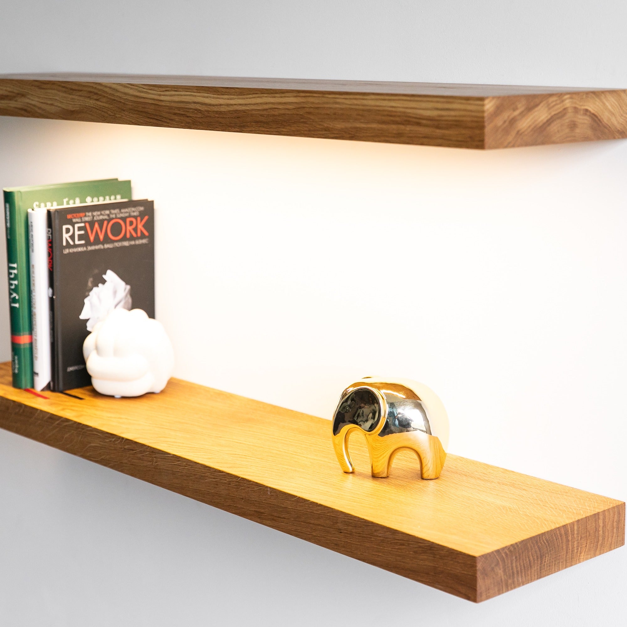 Wooden shelf with books and decorative items on a white background