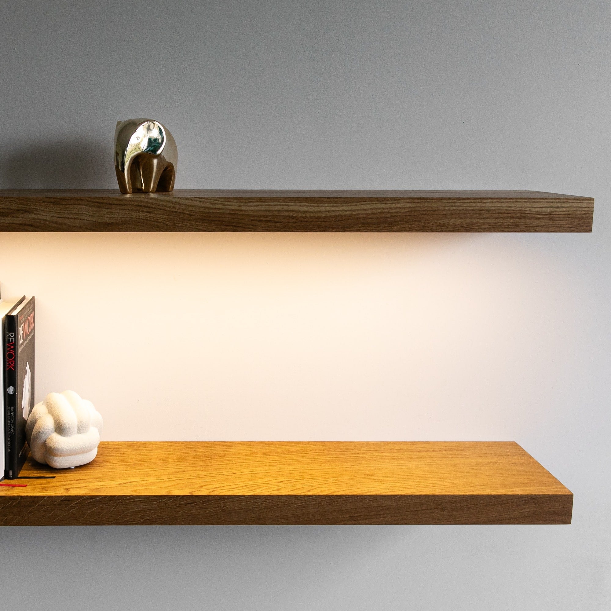 Two wooden shelves with decorative items on a plain background