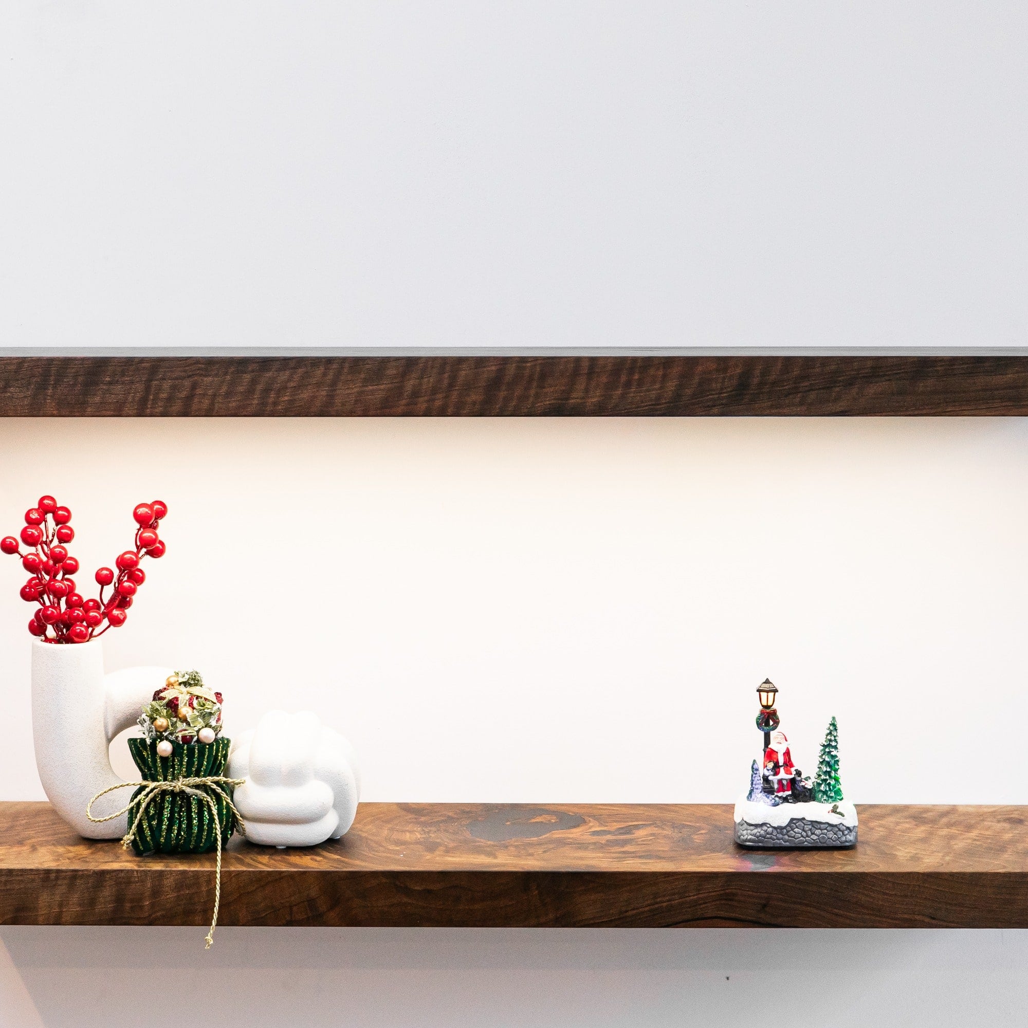 Decorative items on a wooden shelf against a white wall