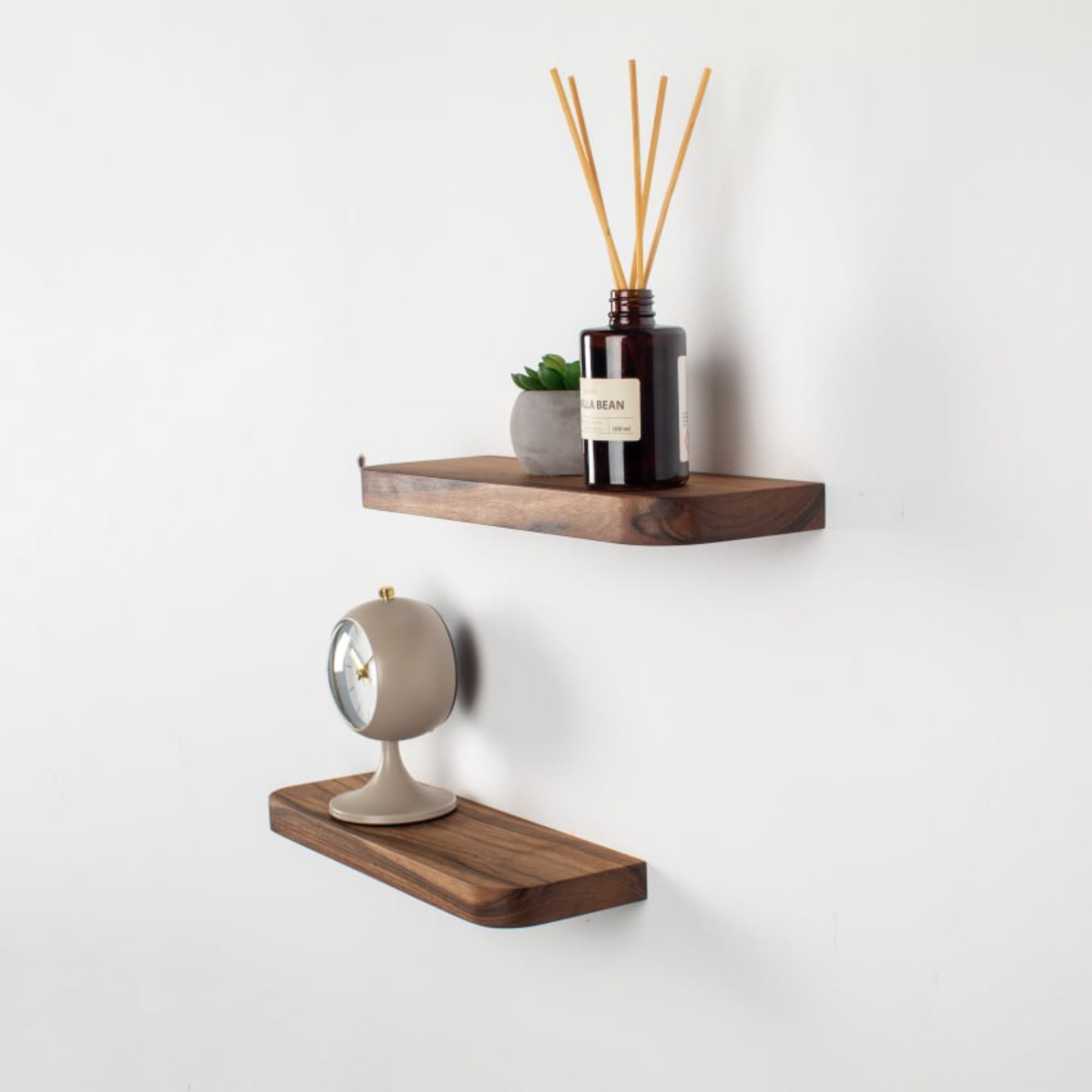Wooden wall shelves with decorative items on a white wall