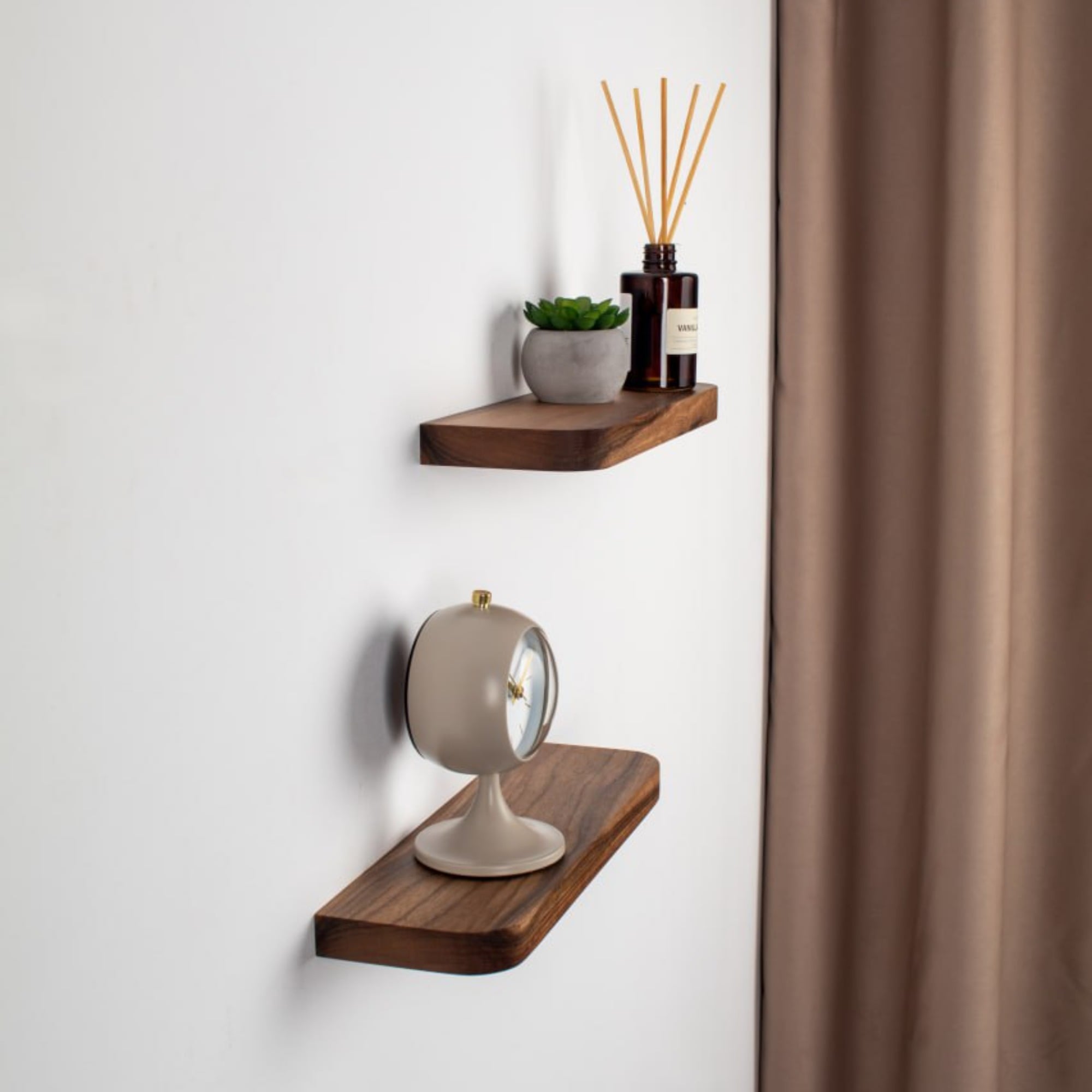 Two wooden wall shelves with decorative items against a white wall.